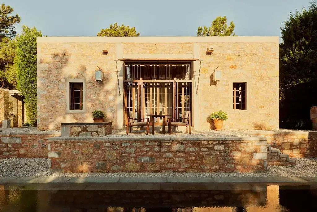 Steingebäude mit Terrasse und Pflanzen des Amanruya Hotels