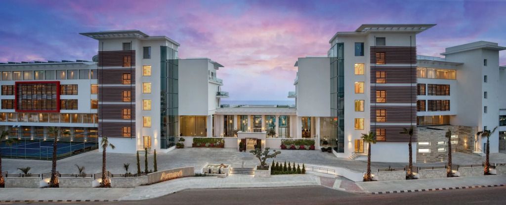 Moderne Hotelfassade bei Sonnenuntergang mit Blick auf das Meer