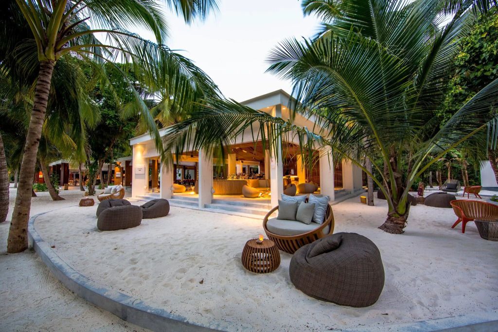 Außenbereich eines stilvollen Restaurants mit Lounge-Sesseln und Palmen