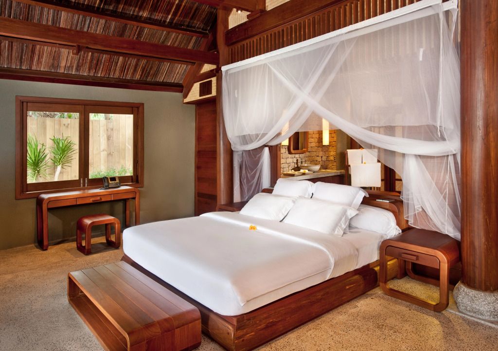 Luxuriöses Zimmer mit Himmelbett und Holzelementen im Hotel L'Alya Ninh Van Bay