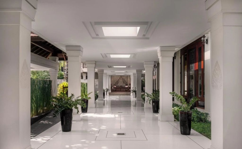 Eleganter weißer Hotelflur mit Pflanzen und Sofa