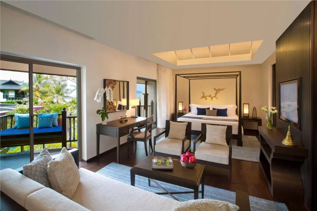 Luxuriöses Zimmer mit Himmelbett und Sitzbereich mit Blick auf den tropischen Garten