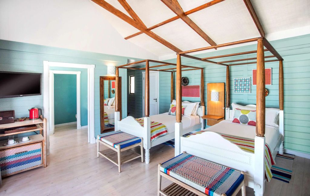 Elegantes Gästezimmer mit Himmelbett und bunter Bettwäsche