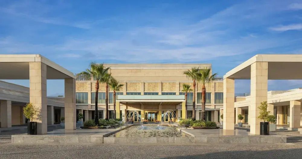 Moderne Hotelarchitektur mit Palmen und Wasserspiel am Eingang