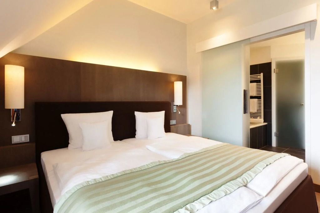 Modernes Hotelzimmer mit Doppelbett und stilvoller Beleuchtung