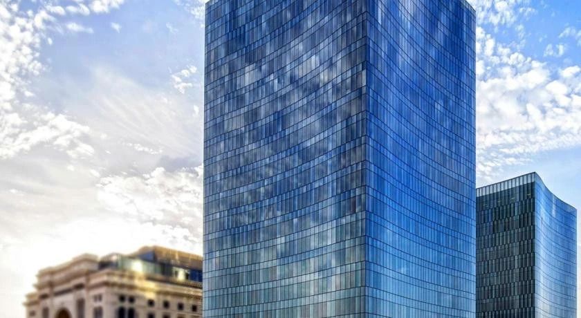 Moderne Glasfassade eines hohen Gebäudes bei Tageslicht