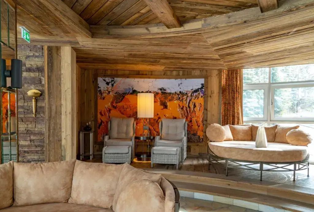 Gemütliche Sitzecke mit Holzwänden und Kunstwerk im Alpin Resort Sacher