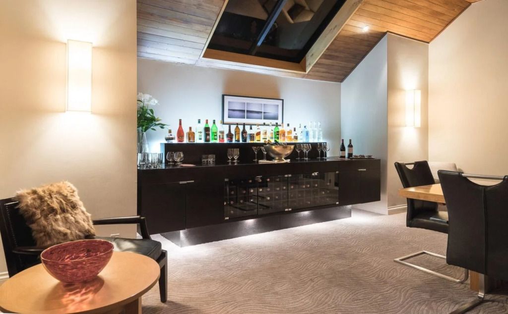 Moderne Bar in Lounge mit vielfältiger Spirituosen-Auswahl und gemütlicher Beleuchtung