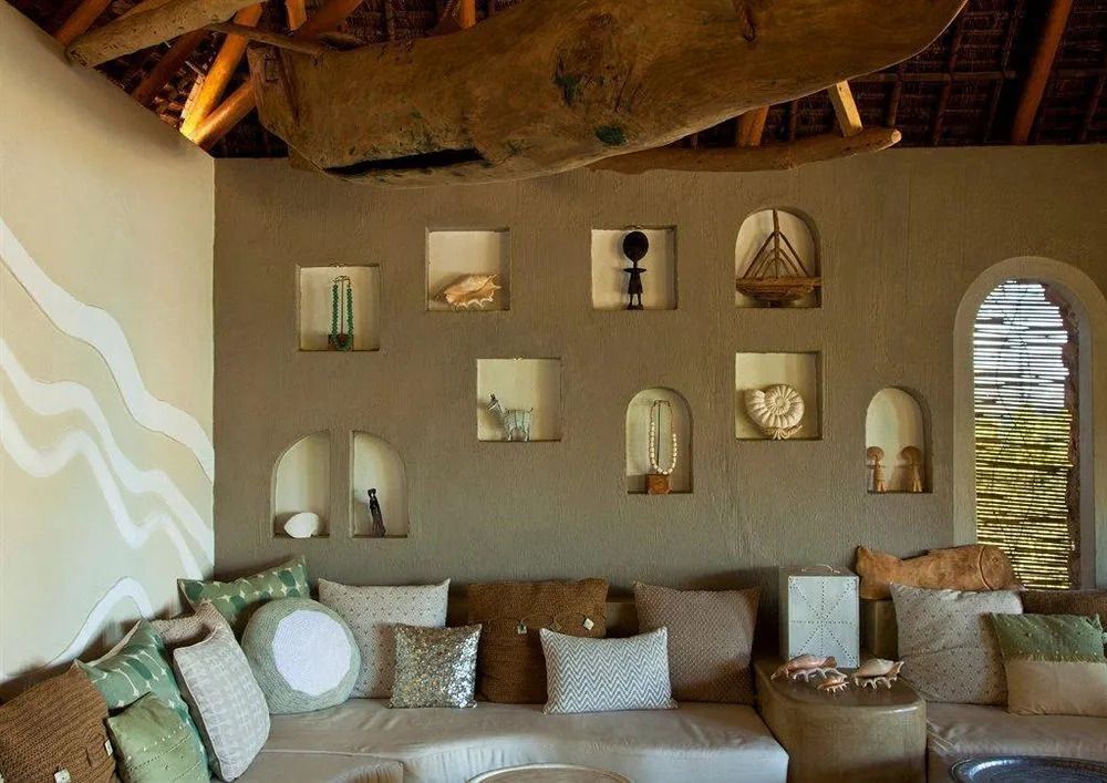 Gemütliche Hotel-Lounge mit dekorativen Nischen und Kissen unter Holzdach