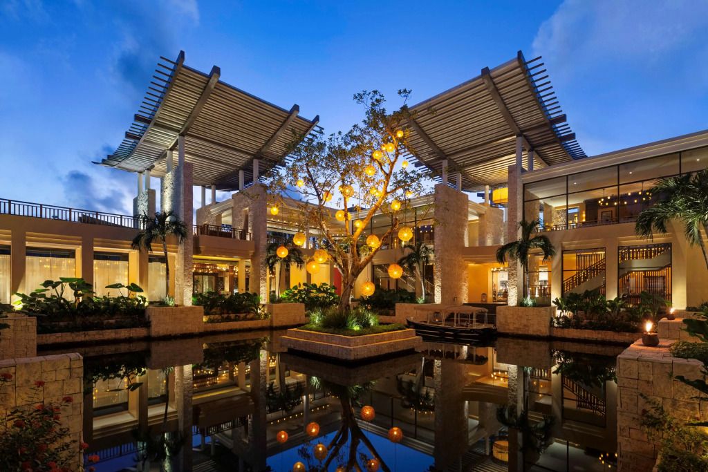 Beleuchteter Empfangsbereich des Banyan Tree Mayakoba mit Wasserbecken und moderner Architektur