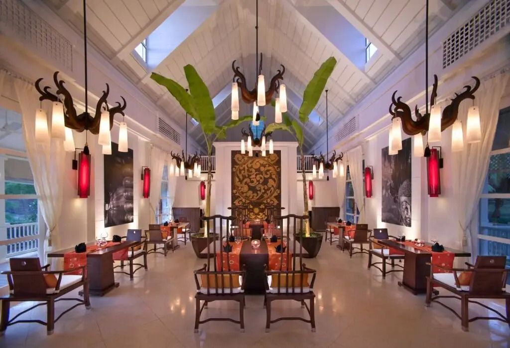 Elegantes Restaurantinterieur mit hoher Decke und exotischen Pflanzen