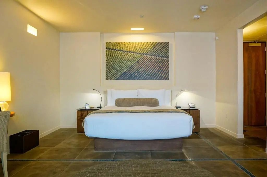 Modernes Hotelzimmer mit großem Bett und Kunstwerk an der Wand