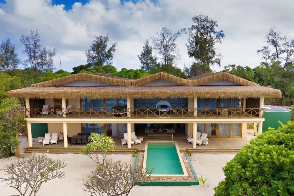 Zweistöckige Villa mit Strohdach und Pool direkt am Strand