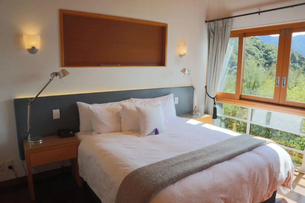 Helles Schlafzimmer mit großem Fenster und Doppelbett im Hotelzimmer