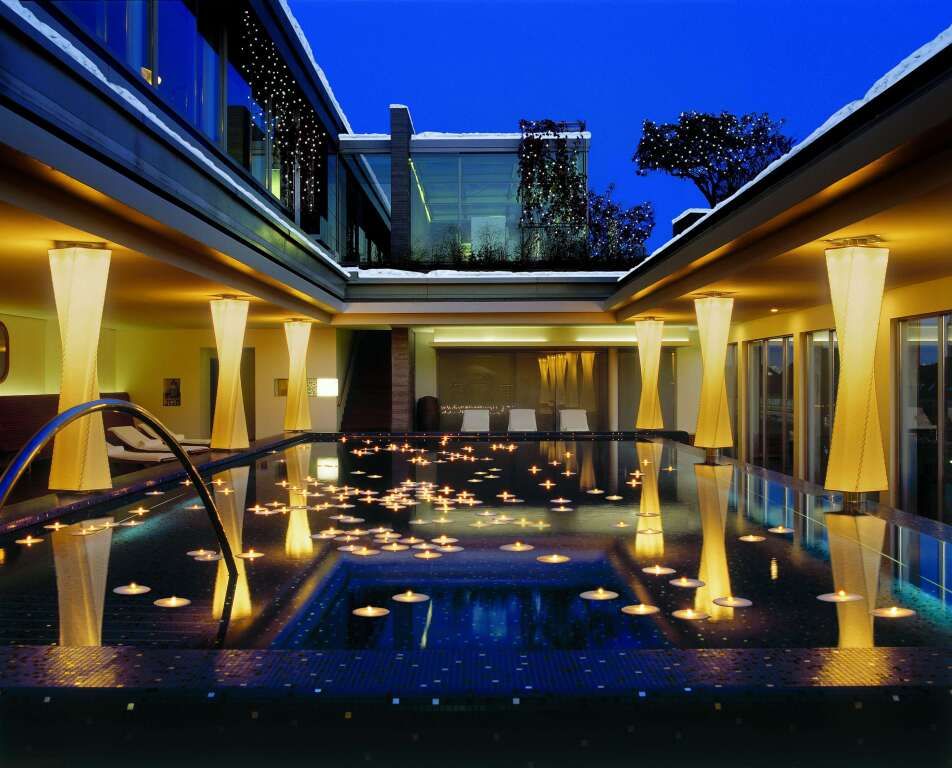 Stimmungsvoller beleuchteter Innenhof mit Pool im Abendlicht