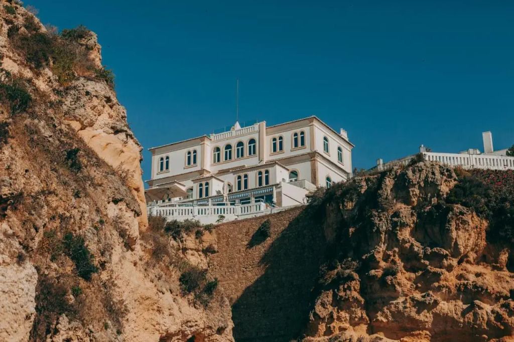 Historische Fassade des Bela Vista Hotels auf einer Klippe mit blauem Himmel