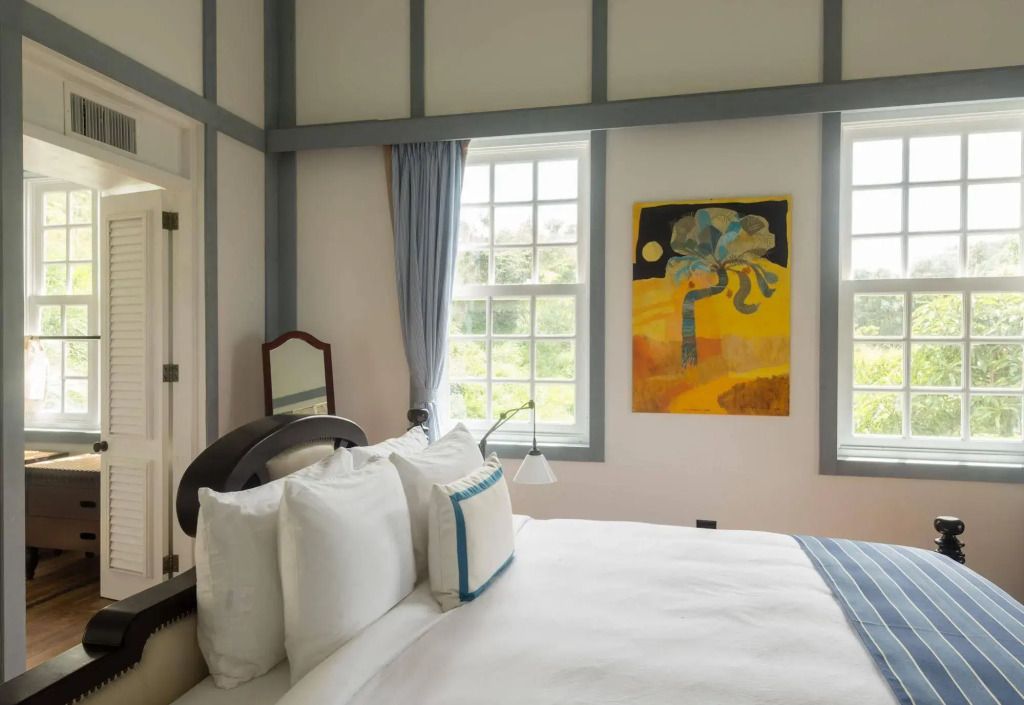 Helles Schlafzimmer mit gestreiftem Bett und moderner Kunst an der Wand