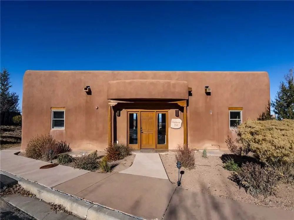 Traditionelle Lehmarchitektur mit Holzeingang und Wüstenlandschaft.