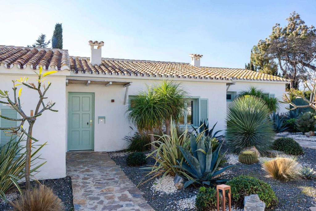 Eingang einer Villa mit Garten und mediterranen Pflanzen