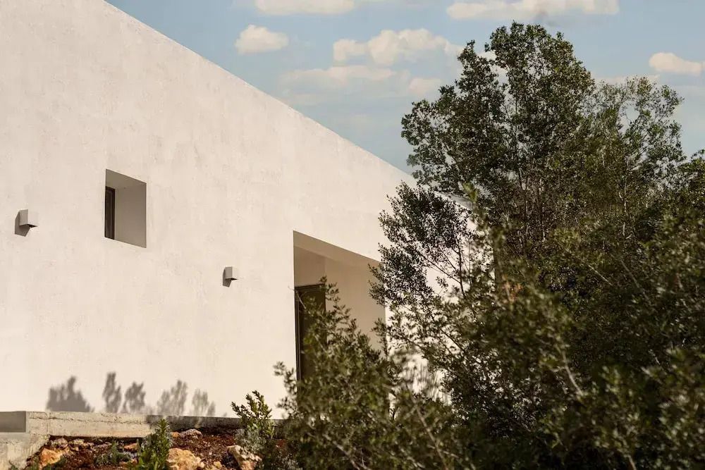 Moderne Villa-Fassade mit natürlichen Elementen umgeben von Landschaft