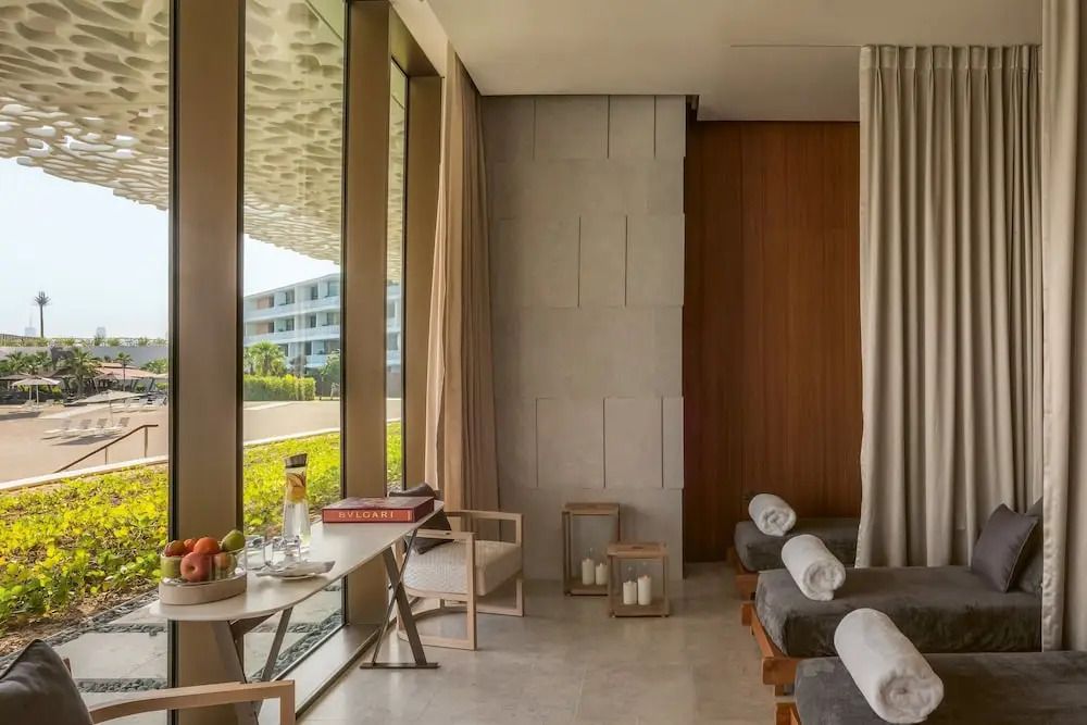 Entspannungsbereich mit Liegen und Blick auf Garten im Bulgari Resort Dubai