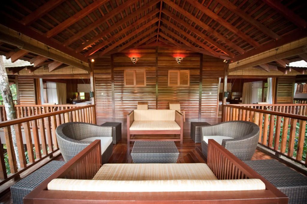 Gemütliche Lounge mit Holzwänden und Rattansesseln im tropischen Stil