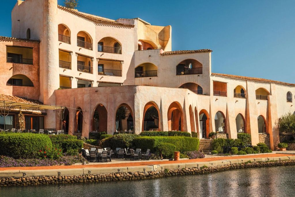 Mediterrane Hotelarchitektur mit Bogengängen am Wasser