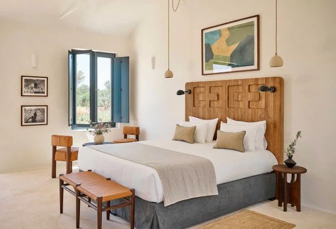 Elegantes Hotelzimmer mit Holzbett, Kunstwerk und natürlichem Licht.