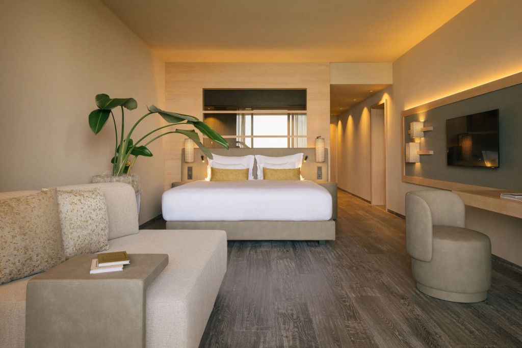 Elegantes Hotelzimmer mit modernen Möbeln und großer Pflanze