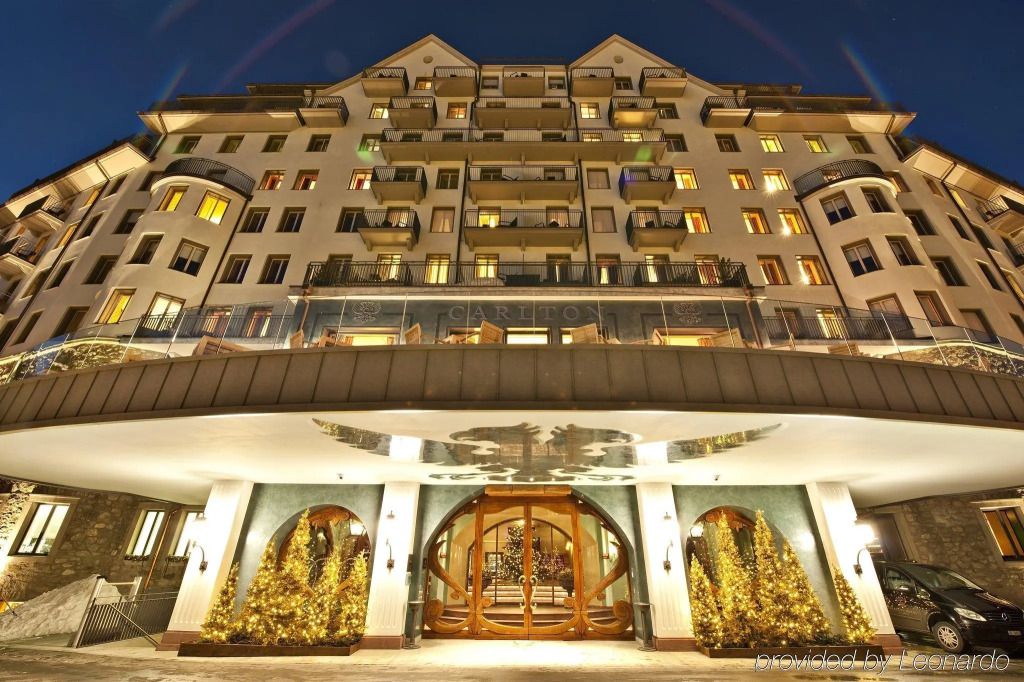 Beeindruckende Fassade des Carlton Hotels bei Nacht mit warm erleuchteten Balkonen