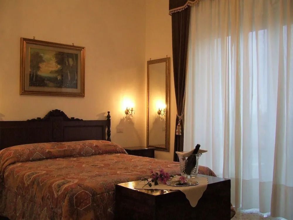 Elegantes Hotelzimmer mit Doppelbett und Vorhängen