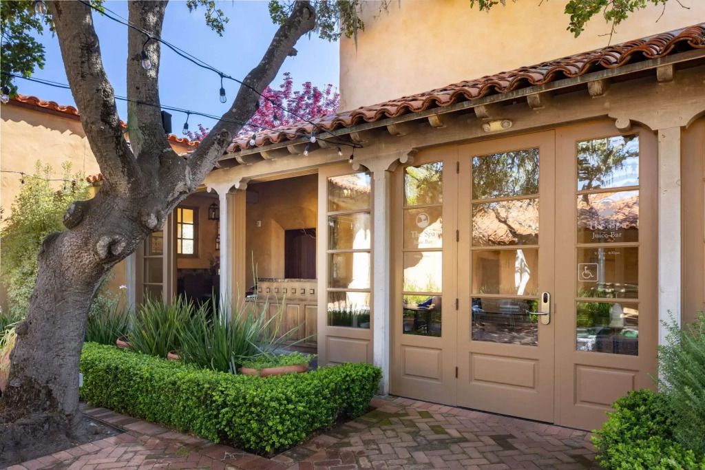 Charmanter Innenhof mit französischen Türen und gepflegten Sträuchern