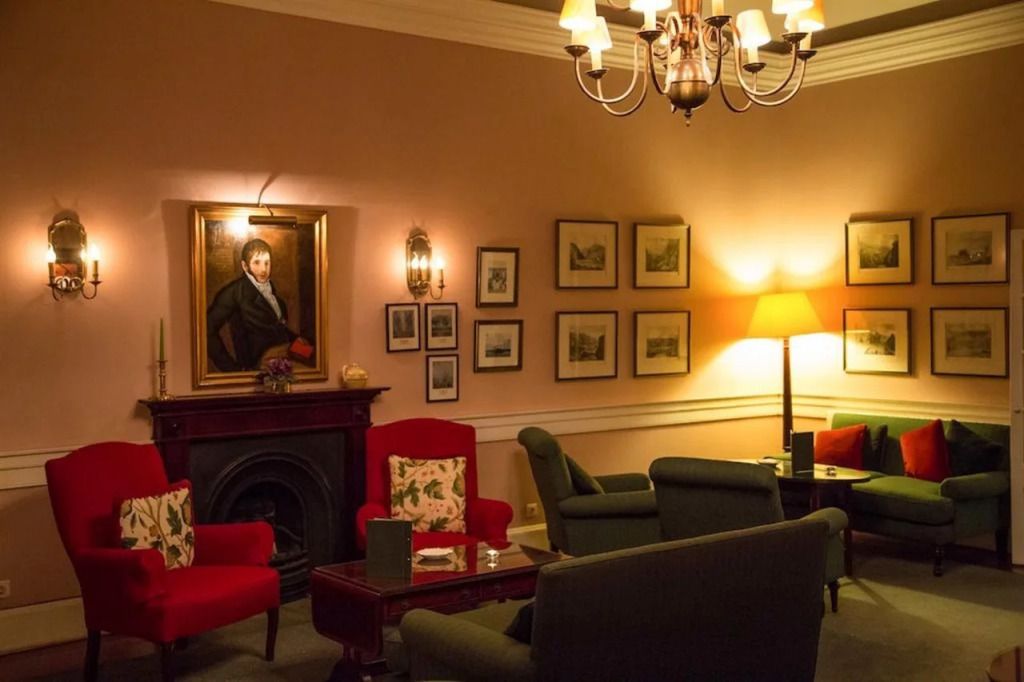 Elegante Lounge mit klassischen Möbeln und Porträtmalerei an der Wand