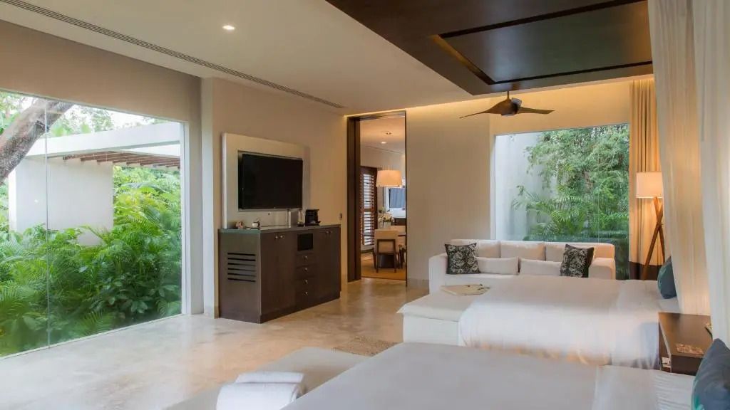 Luxuriöses Hotelzimmer mit Blick ins Grüne und modernen Möbeln.