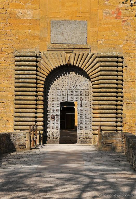 Historisches Tor mit kunstvollen Steindekorationen und großer Holzpforte