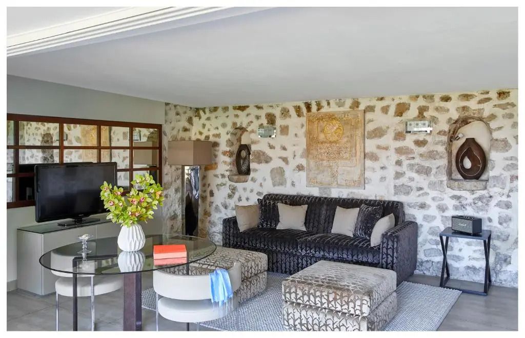 Elegantes Wohnzimmer im Hotel mit Steinwänden und stilvollen Möbeln.