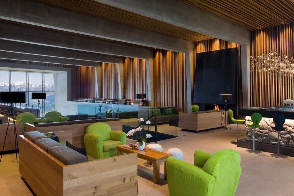 Moderne Hotellounge mit grünem Mobiliar und Kamin