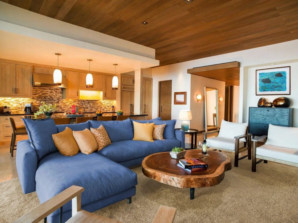 Luxuriöses Wohnzimmer mit blauer Couch und Holzakzenten im Chileno Bay Resort