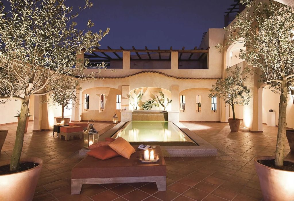 Eleganter Innenhof mit Pool und mediterraner Atmosphäre bei Nacht