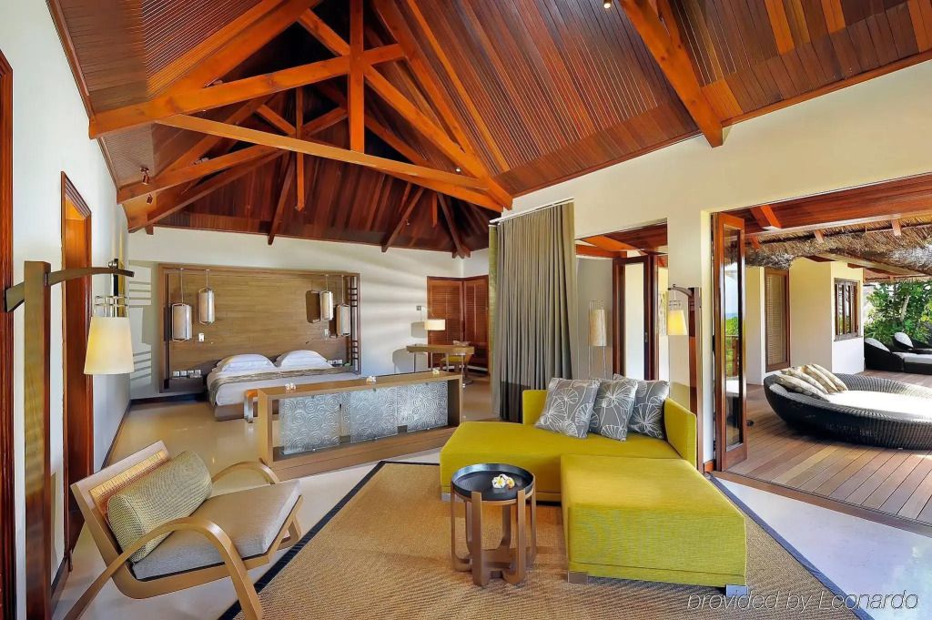 Elegante Hotelsuite mit Holzbalkendecke und moderner Einrichtung.