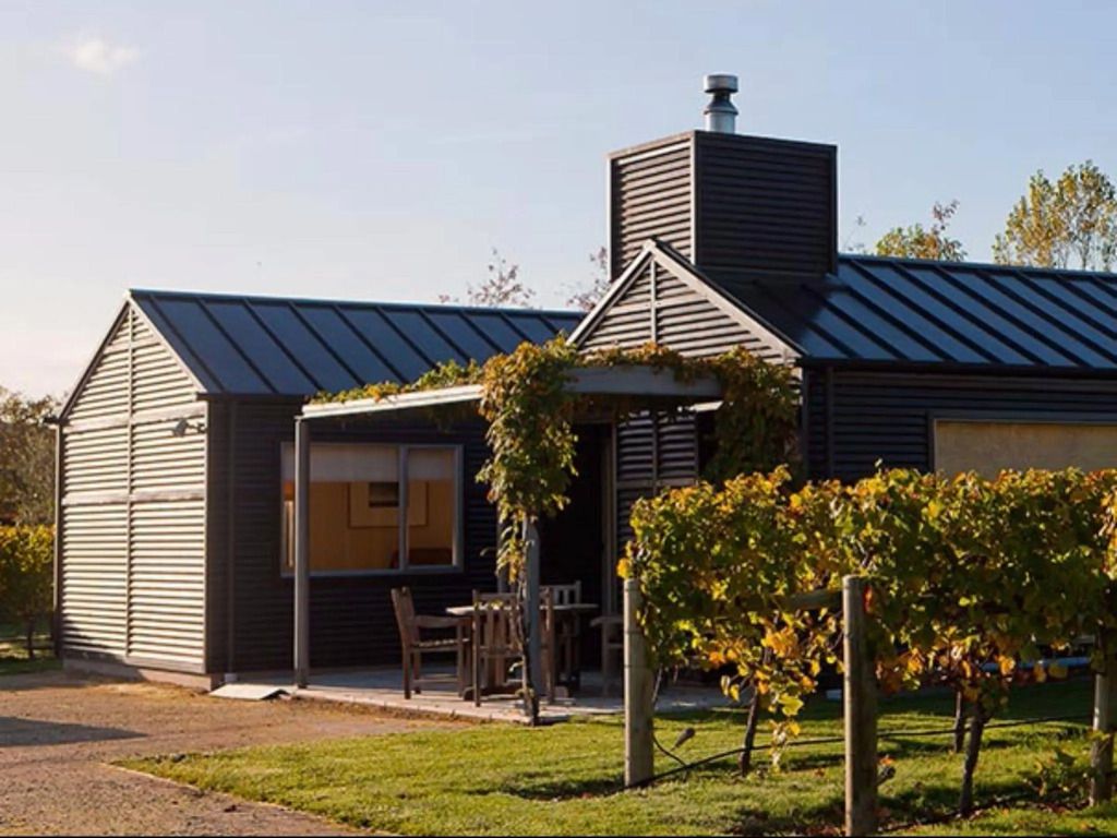 Moderne, gemütliche Hütte mit Terrassenbereich und umgeben von Weinreben.