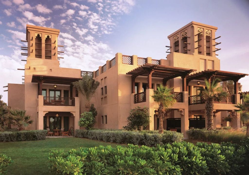 Traditionelle arabische Architektur mit grüner Gartenanlage bei Jumeirah Dar Al Masyaf