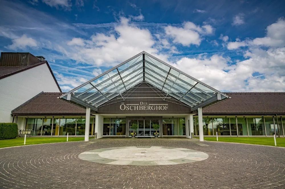 Elegante Hotelarchitektur mit gläsernem Eingangsbereich und blauem Himmel.