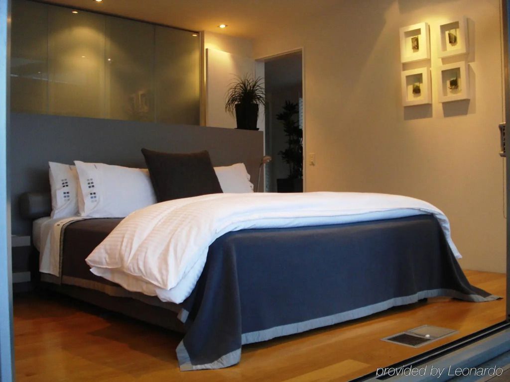 Modernes Hotelzimmer mit gemütlichem Kingsize-Bett und dezenter Beleuchtung