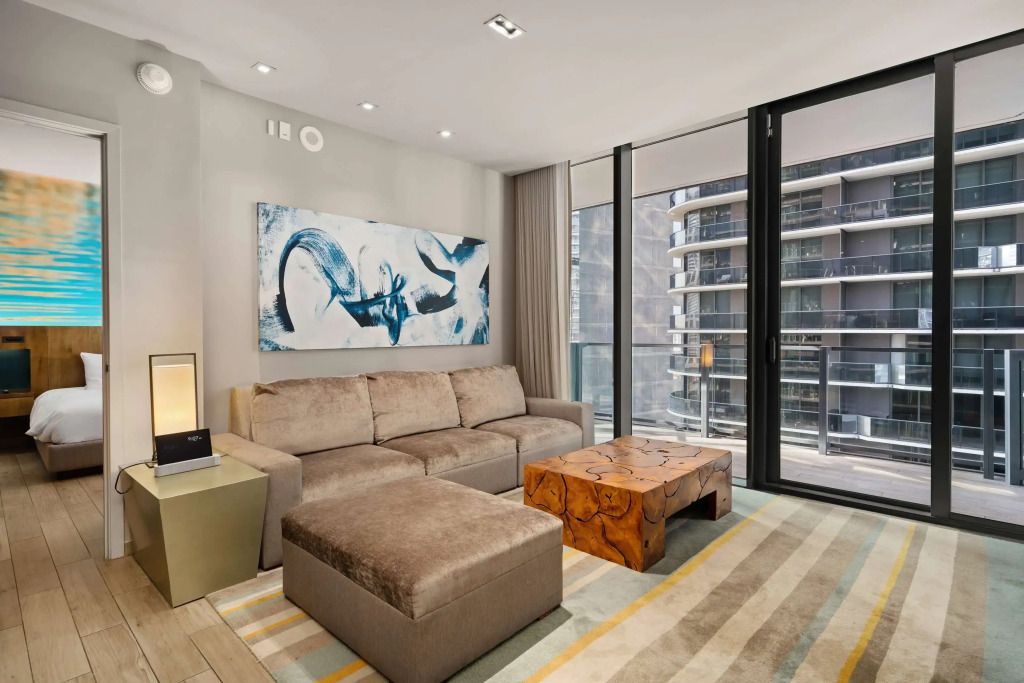 Elegantes Wohnzimmer einer Suite mit moderner Kunst und großer Fensterfront