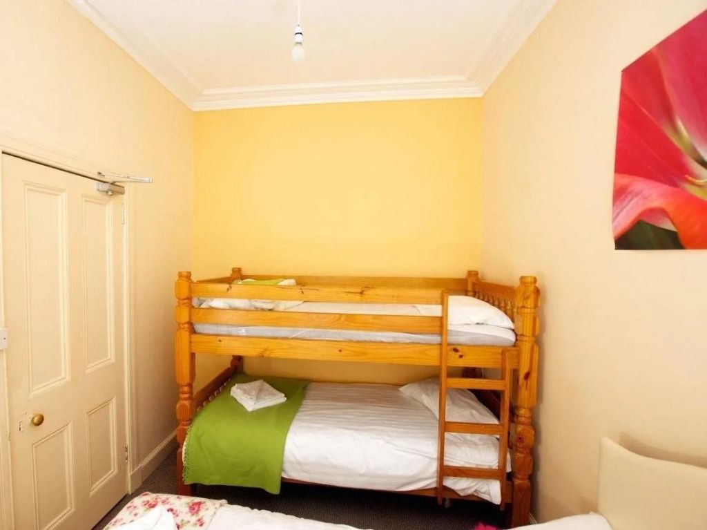 Zimmer mit Etagenbett und warmen gelben Wänden