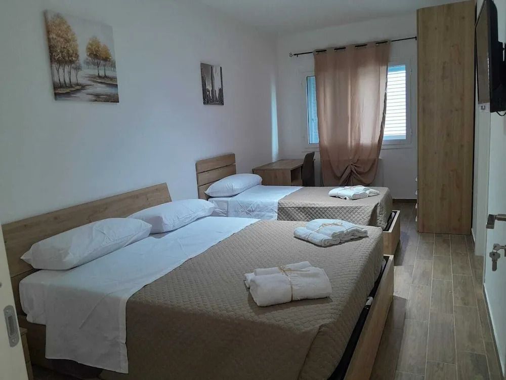 Doppelzimmer mit zwei Einzelbetten und minimalistischer Dekoration