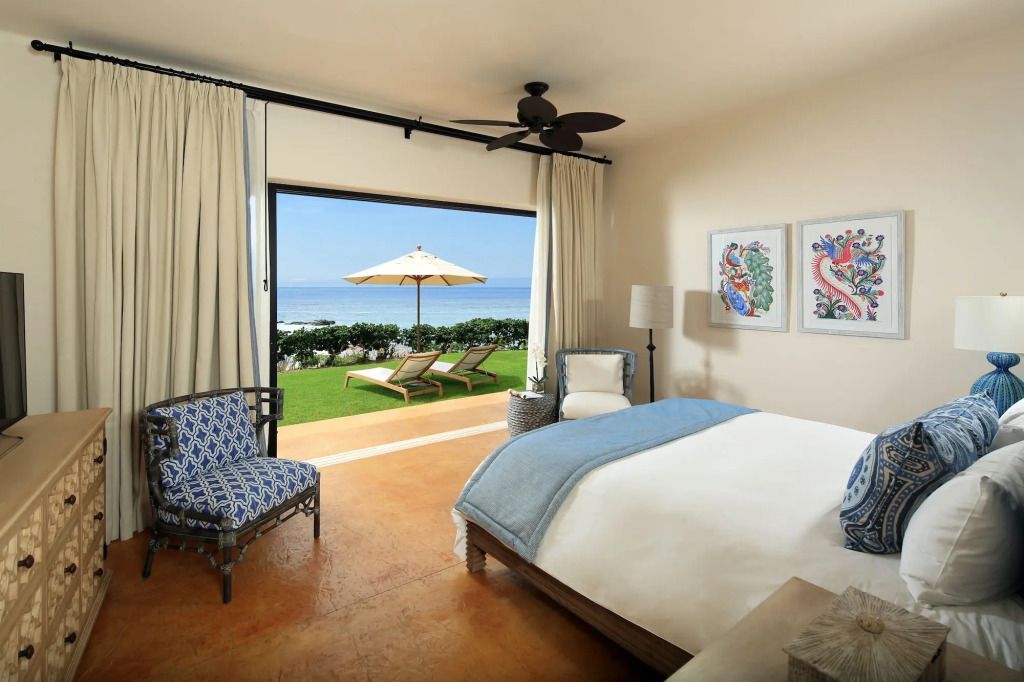 Helles Zimmer mit direktem Blick auf das Meer und privater Terrasse mit Liegestühlen.