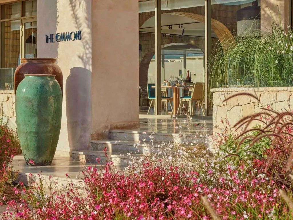 Eingangsbereich eines stilvollen Restaurants mit blühenden Blumen im Vordergrund