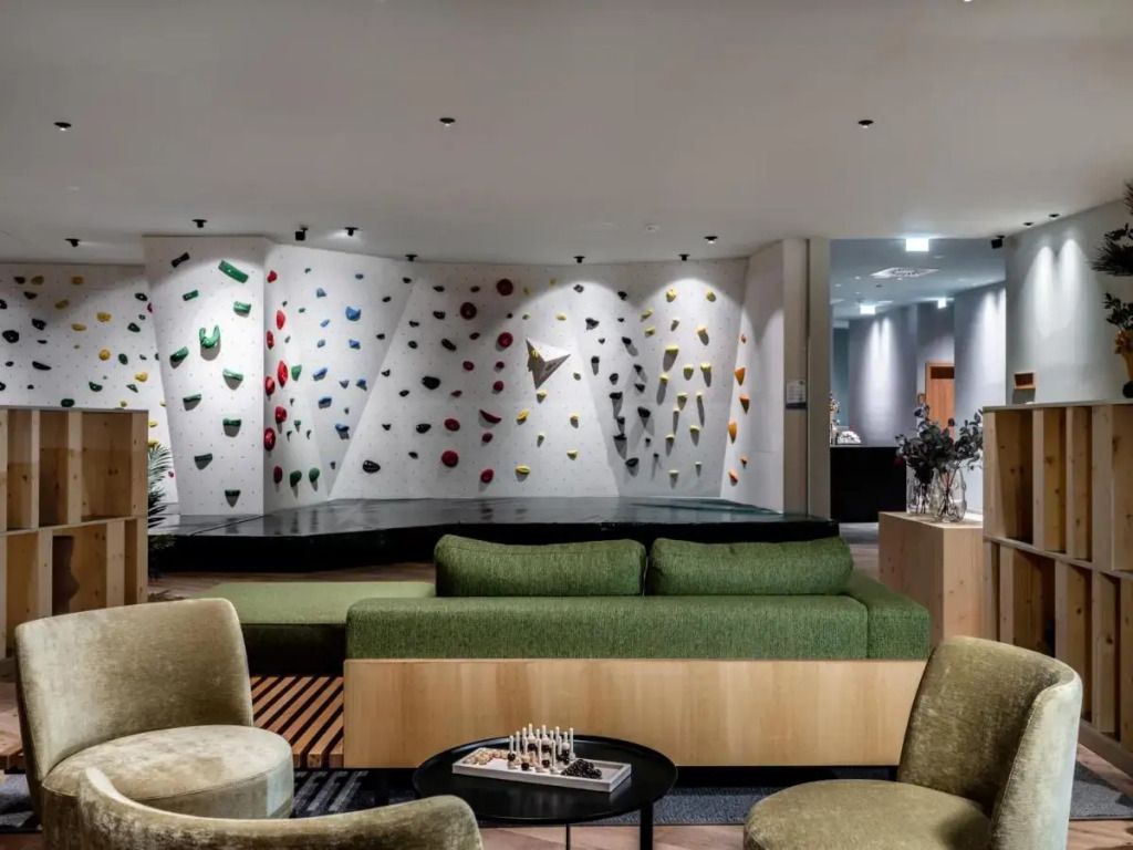 Moderne Hotellobby mit einzigartiger Kletterwand und gemütlicher Sitzecke